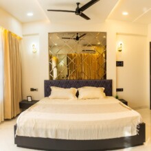 Invest in luxury, live in comfort – Explore our exclusive villas in Vasai at Ivy Dreamland today! a bed with a mirror above it - Ivy Dreamland